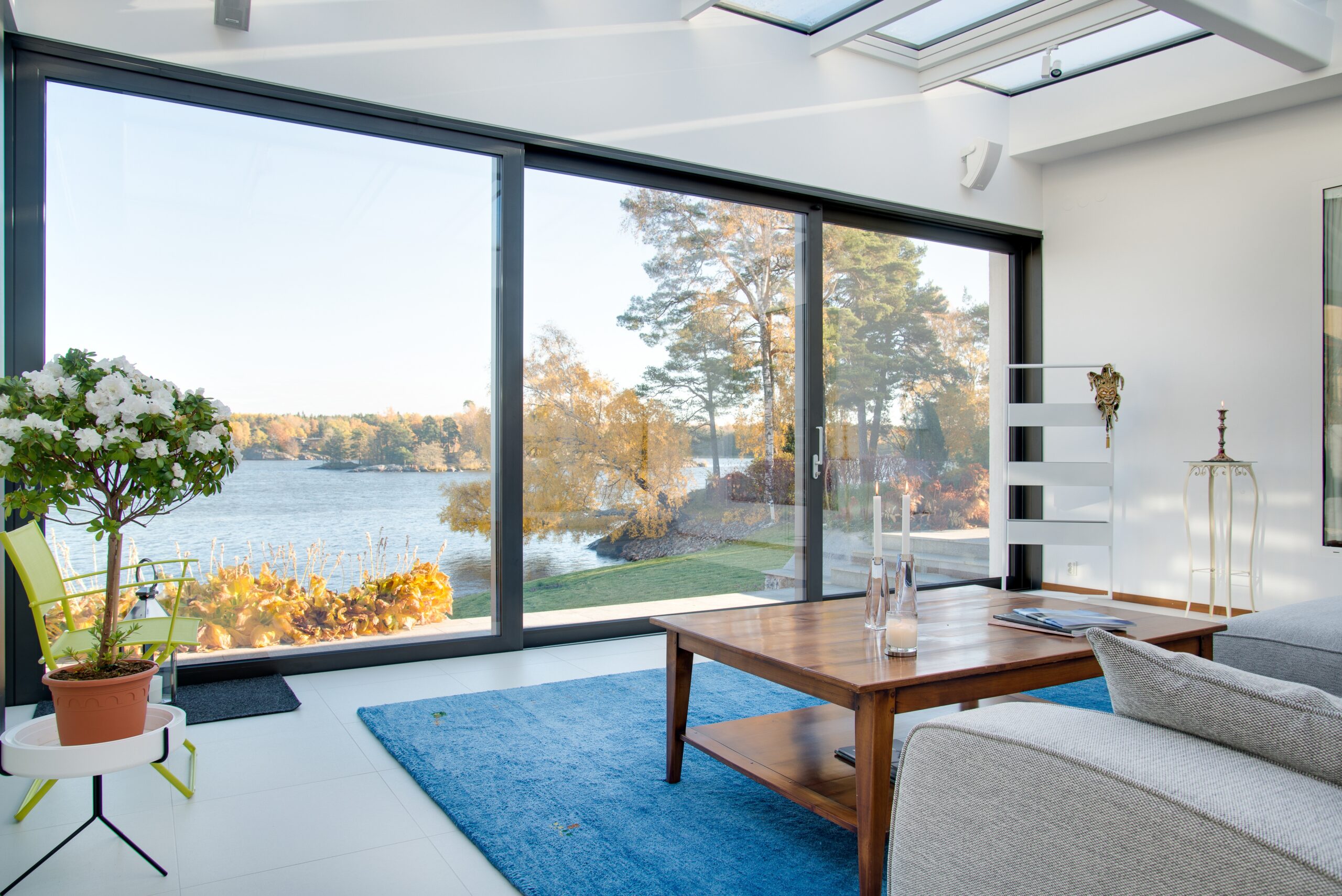 Beautiful view of a blue lake captured from the inside of a villa Sunroom for Winter Gatherings